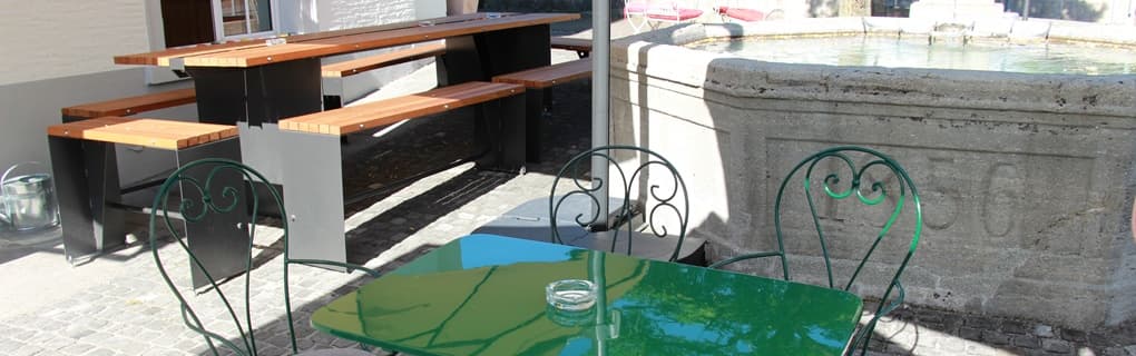 Terrasse des Barcelona Central mit grünen Bistromöbeln am Brunnen